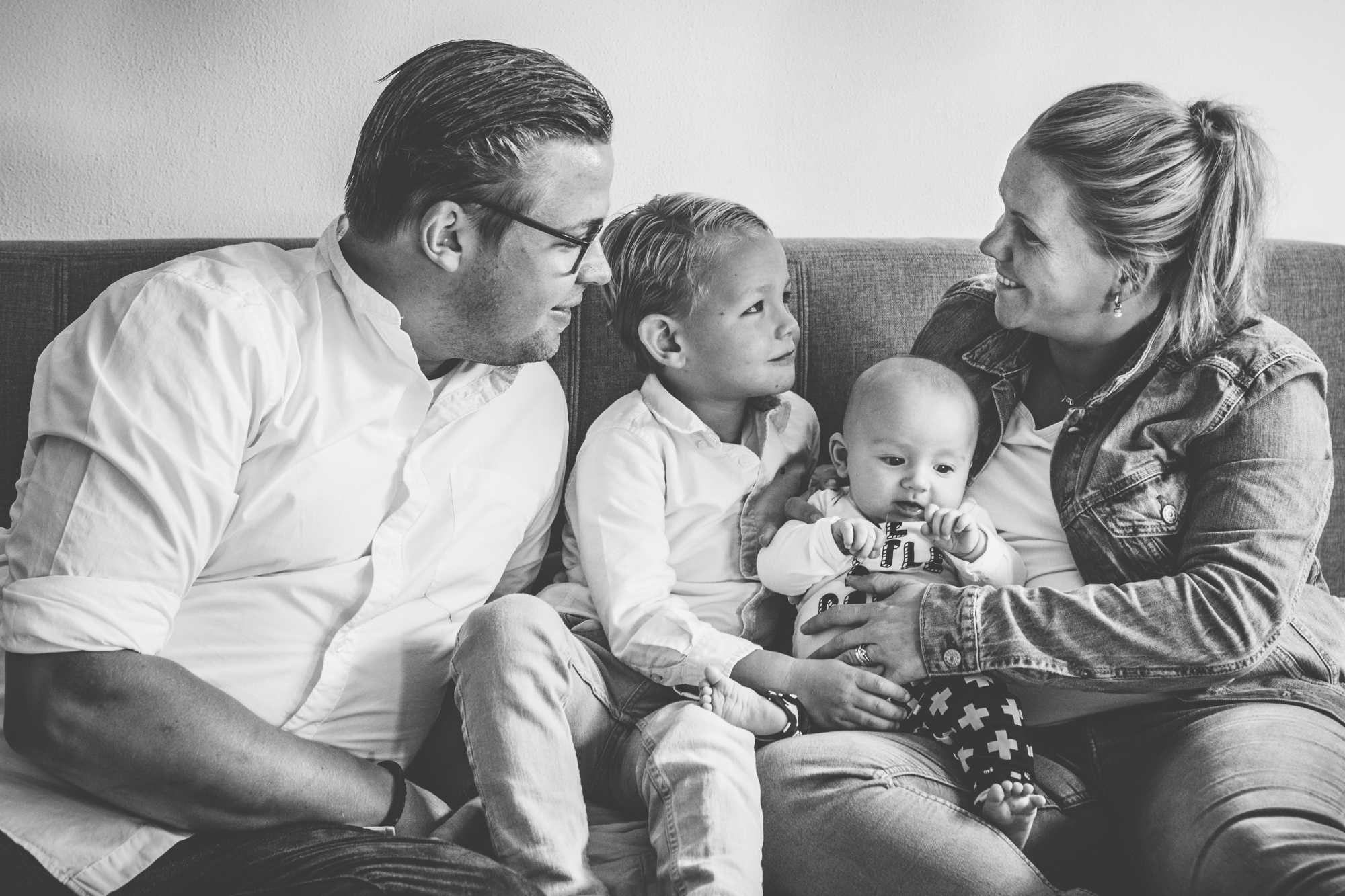 Familie met baby en zoon gezamenlijk op de bank