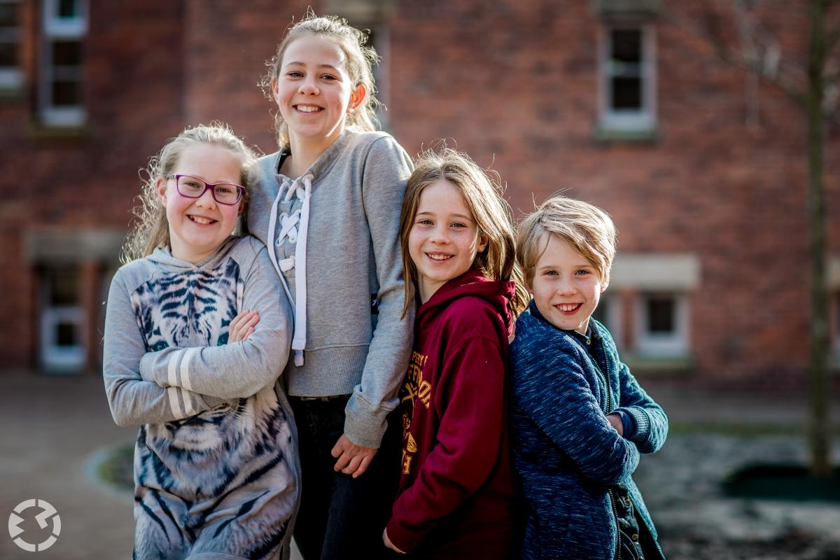 Portretfoto van 4 kinderen achter het oude Raadhuis in Waalwijk