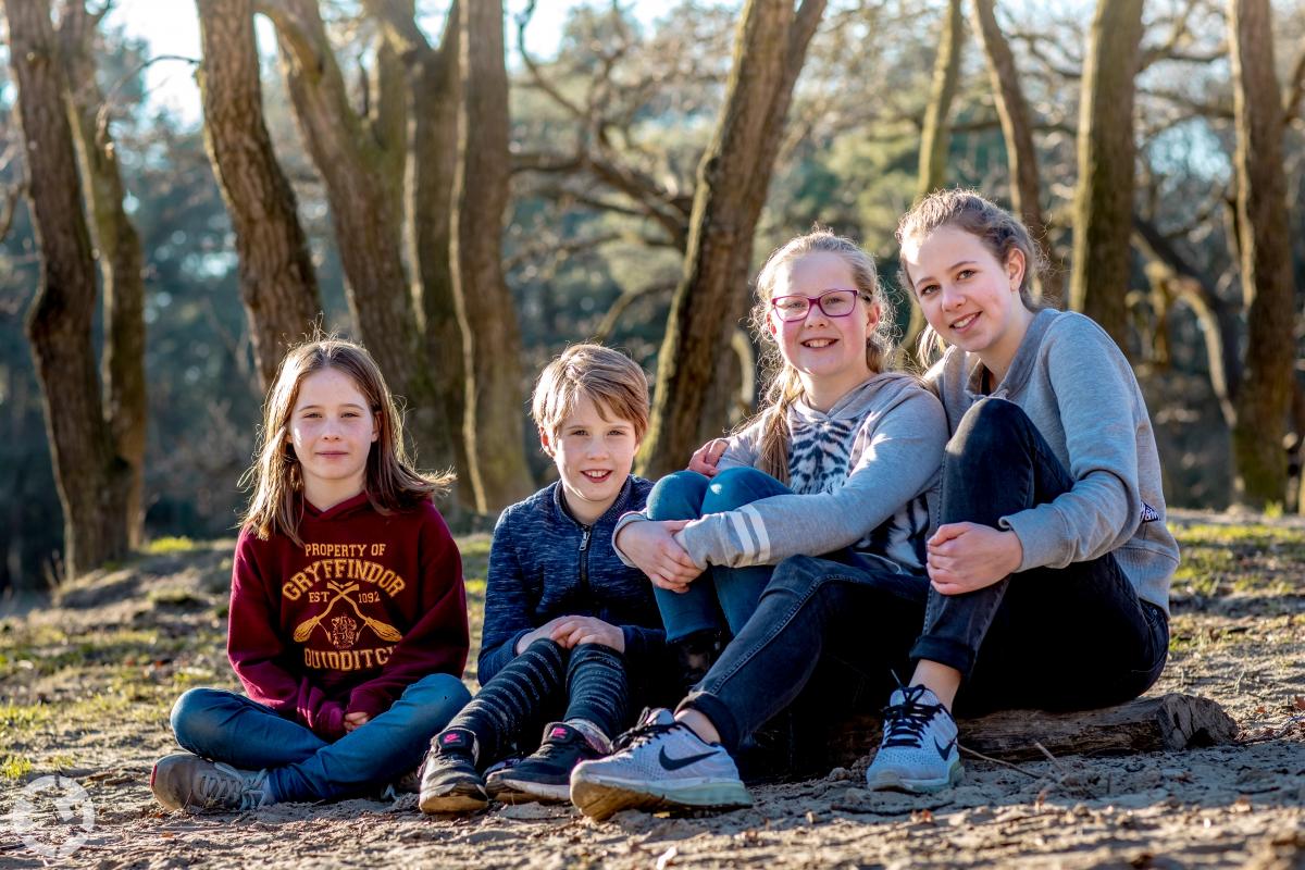 Portretfoto van 4 kinderen zittend in de Loonse en Drunense Duinen in Kaatsheuvel