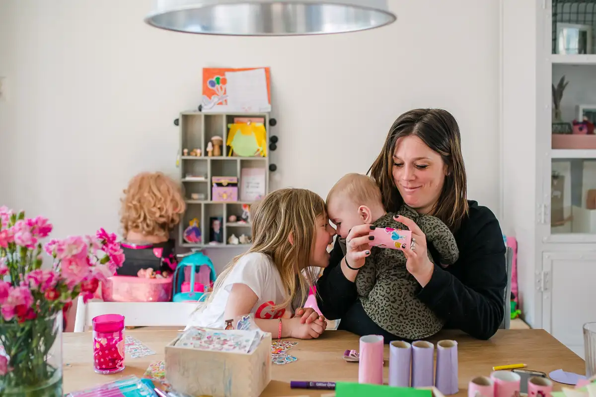 Moeder knutselt met dochters tijdens een niet geposeerde fotosessie.
