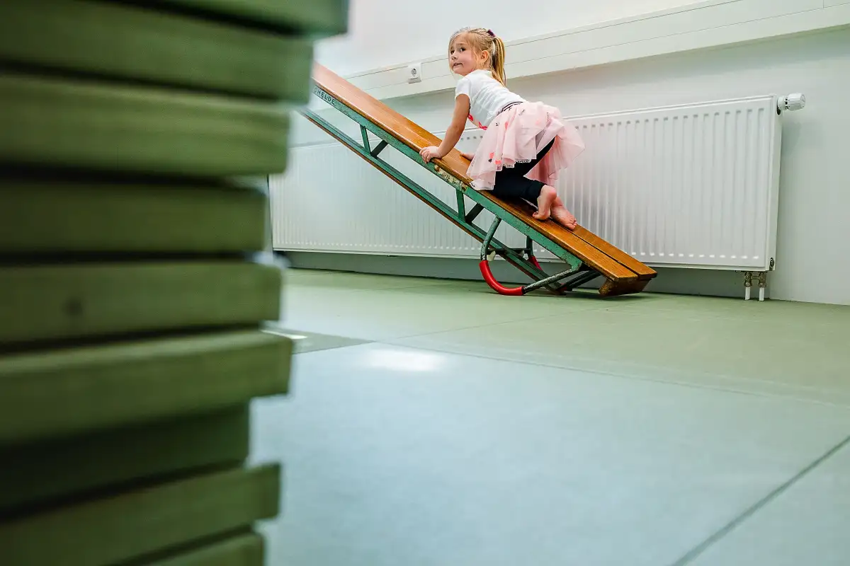 Fotoreportage van een meisje tijdens gymles voor kleine kindjes.