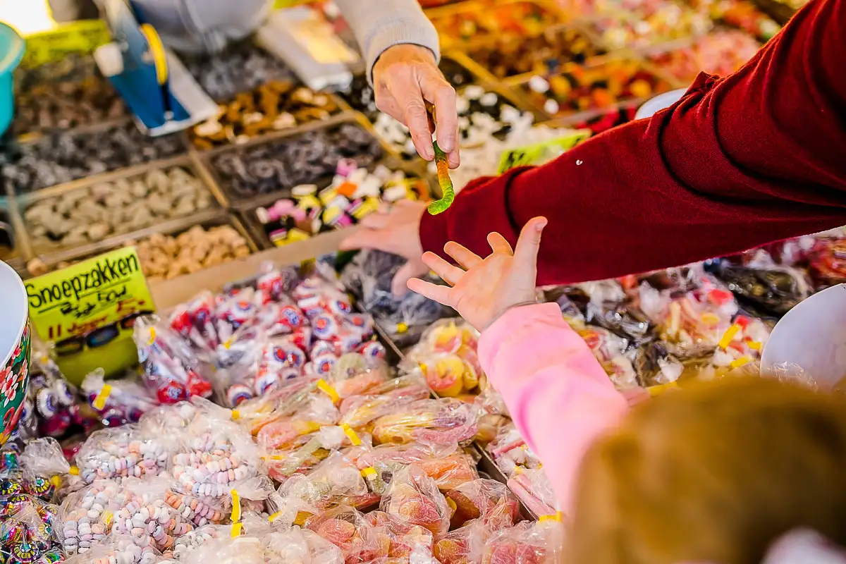 Kinderhandje krijgt een snoepje op de markt.