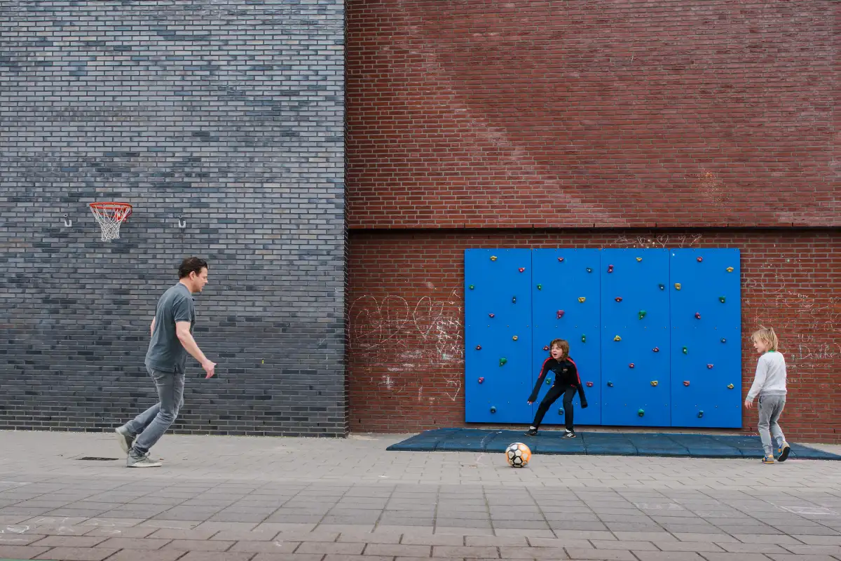 Vader met twee zoontjes voetbalt tijdens een Day in the Life fotoreportage.