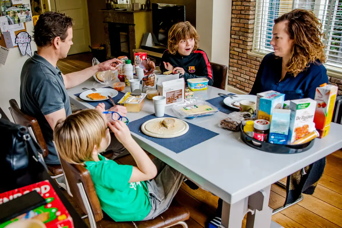 Gezin eet lunch aan de keukentafel tijdens een Day in The Life fotoreportage.