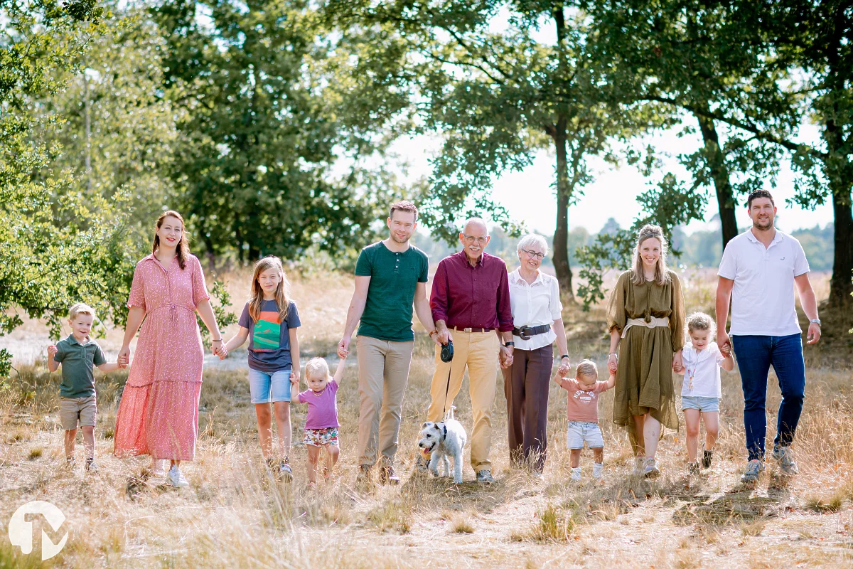 familie met kleine kinderen en een hond lopen hand in hand in de loonse en drunense duinen tijdens een fotoshoot