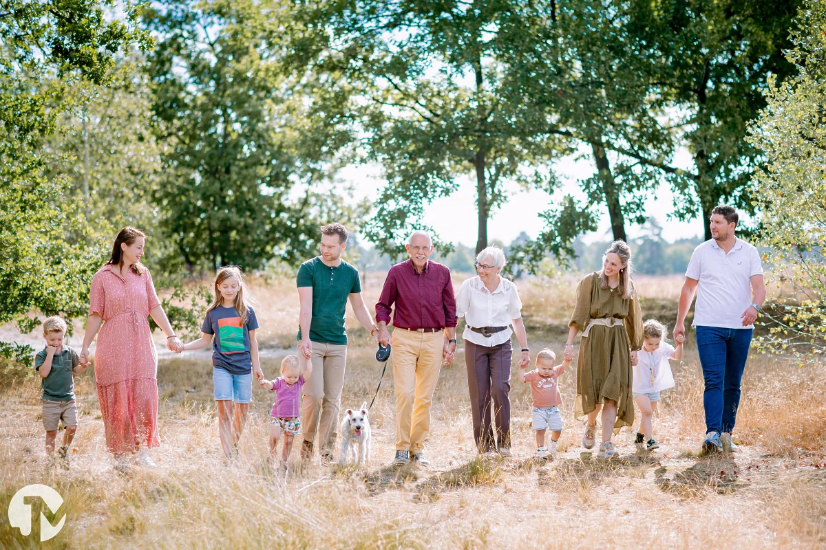 grote familie met kinderen lopen hand in hand door de loonse en drunense duinen