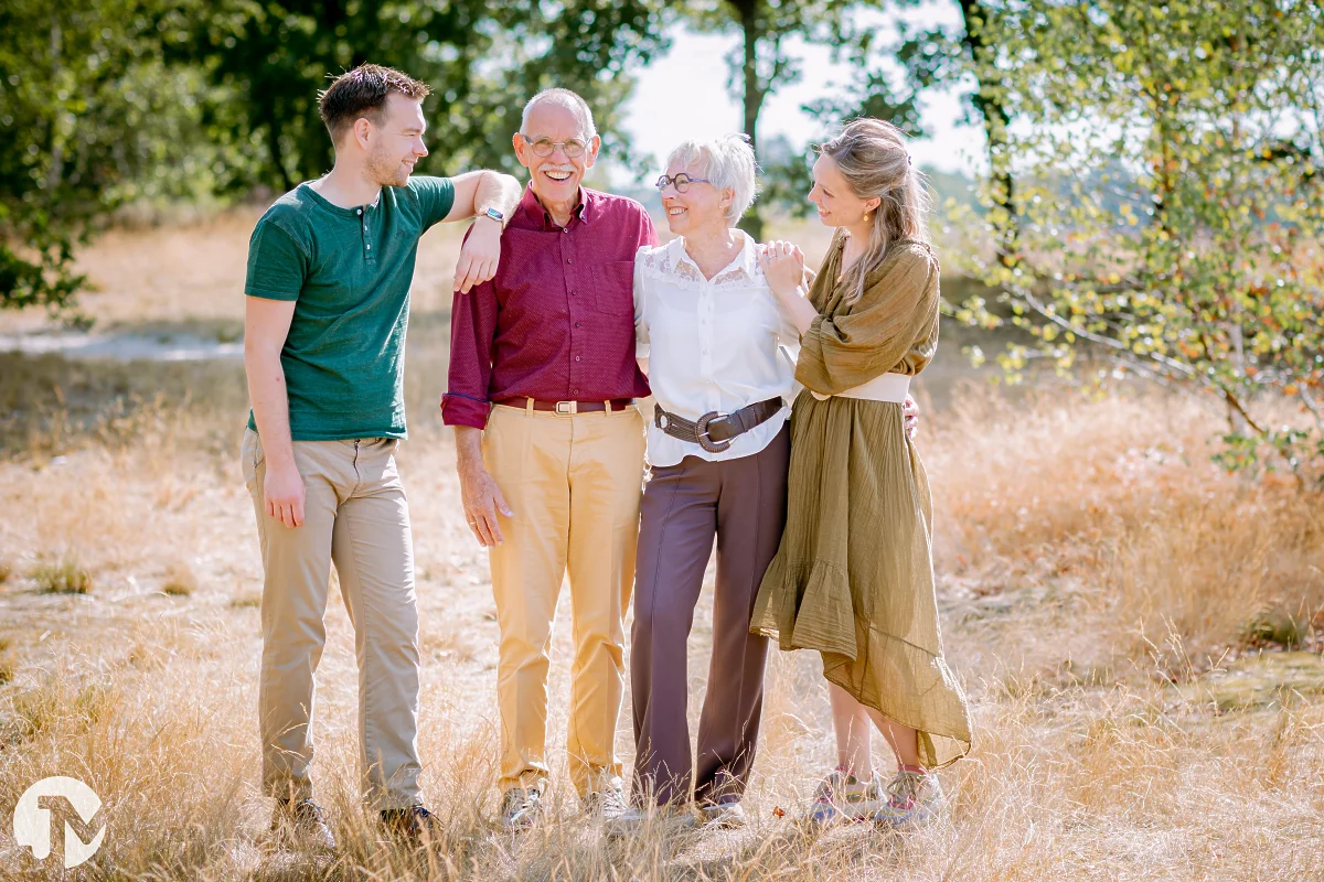 familie met twee volwassen kinderen staan in de loonse en drunense duinen en hebben en interactie