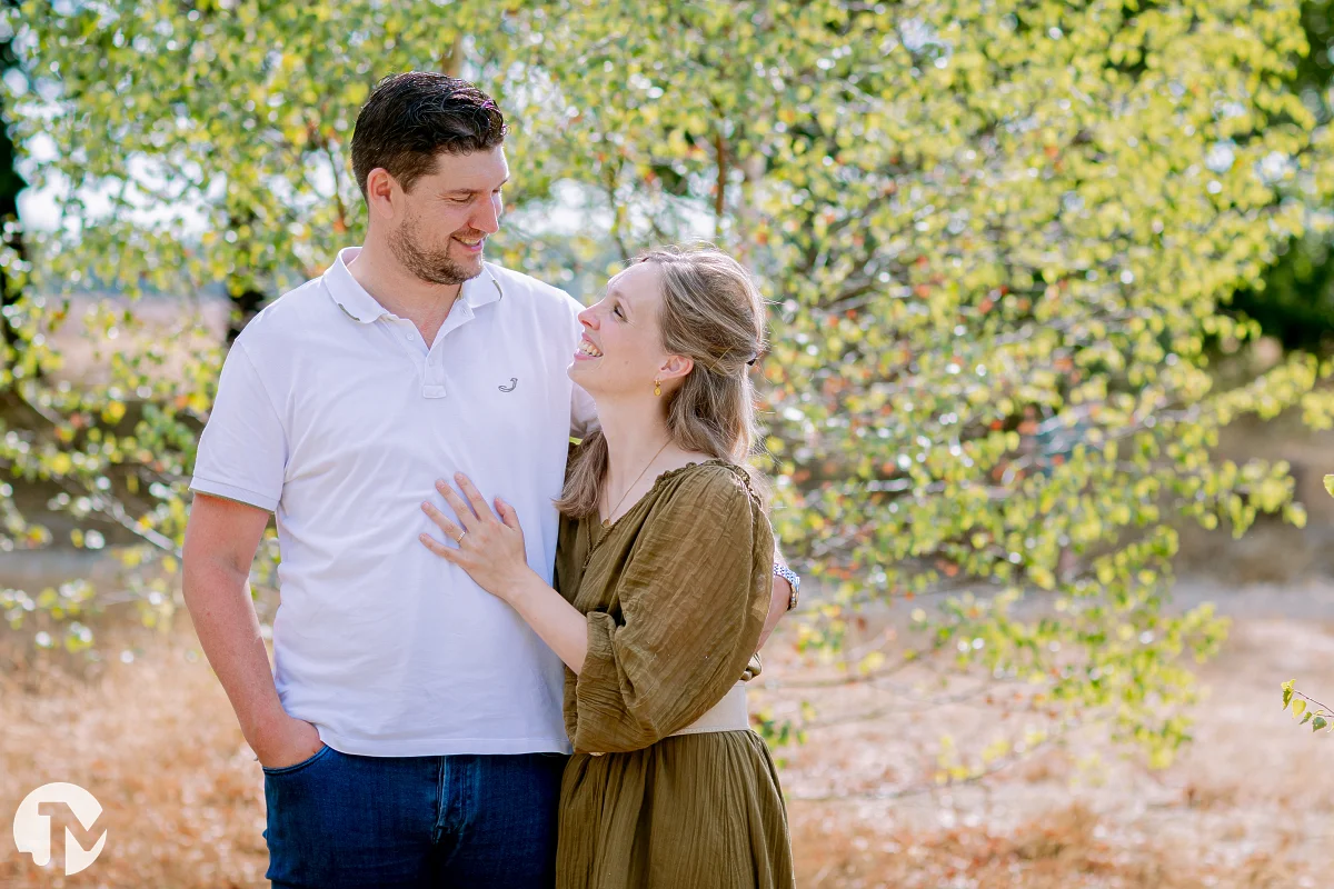 man en vrouw houden elkaar vast en kijken elkaar lachend aan tijdens een fotoshoot bij de Roestelberg in kaatsheuvel