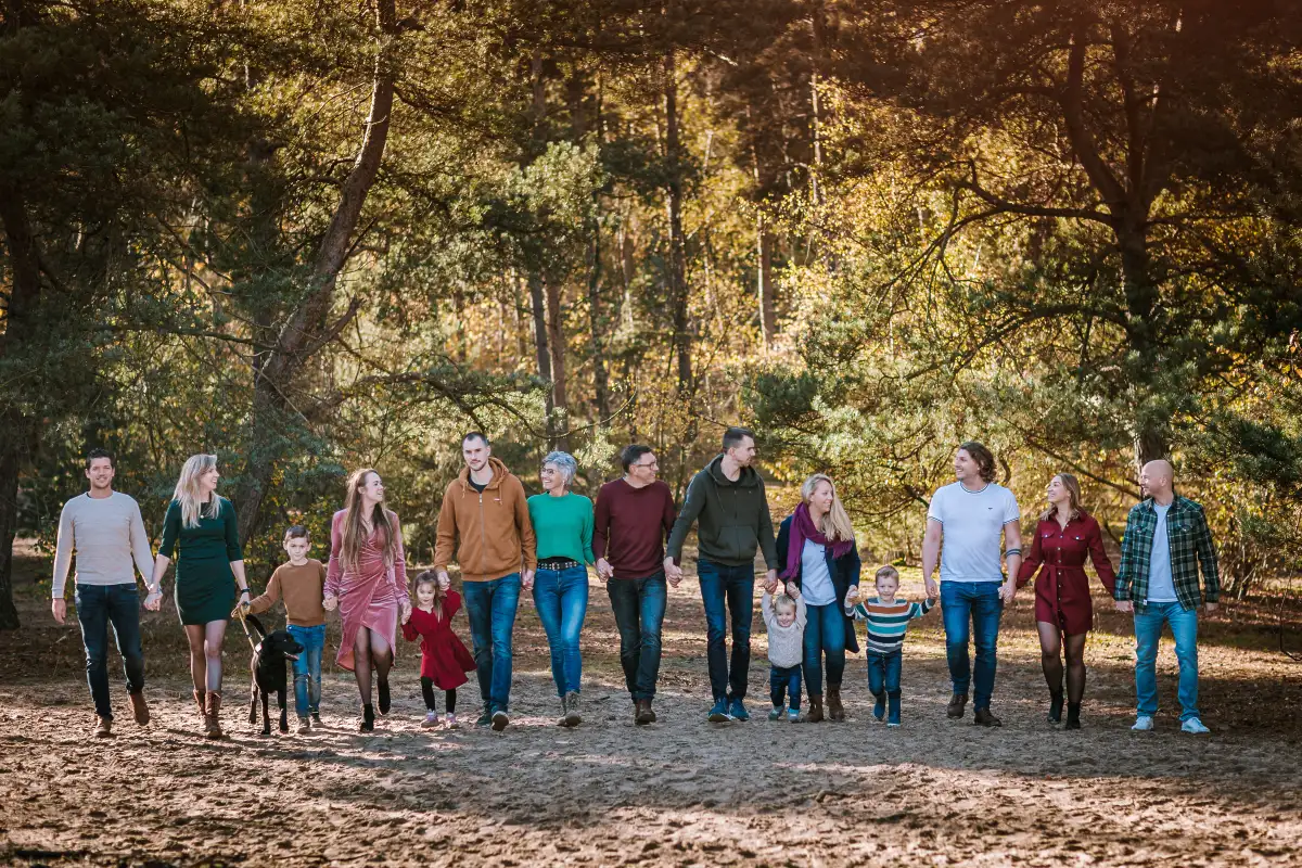 Een grote familie met kleinkinderen poseert staand in de natuur bij de Katjeskelder in Oosterhout.
