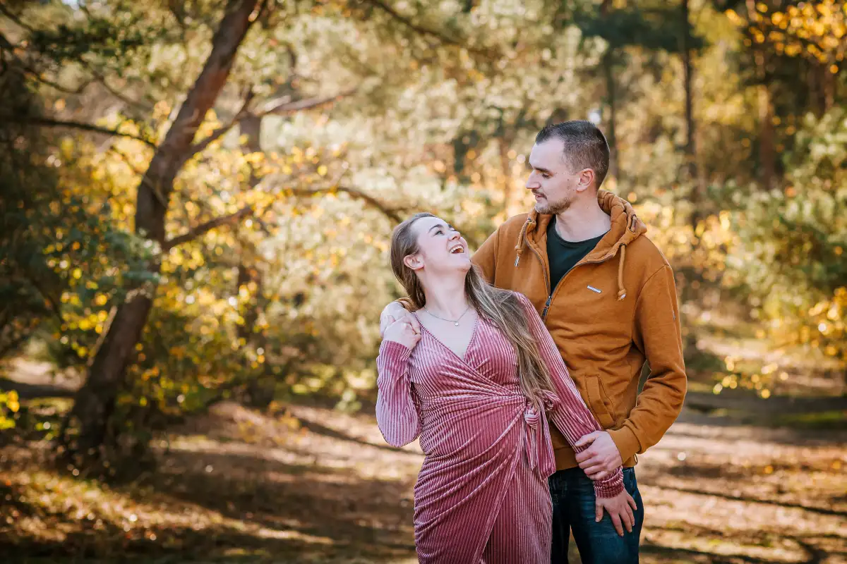 Vader met 2 volwassen kinderen poseren op een zonnige dag in de herfst.
