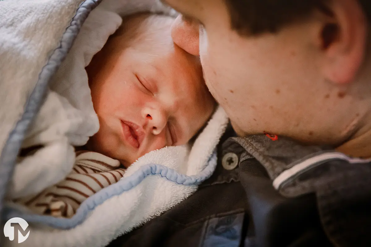 vader knuffelt innig met zijn pasgeboren baby