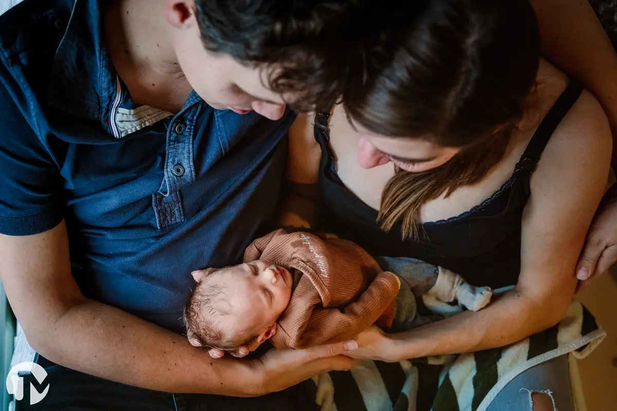 ouders knuffelen met hun premature baby van bovenaf gefotografeerd.