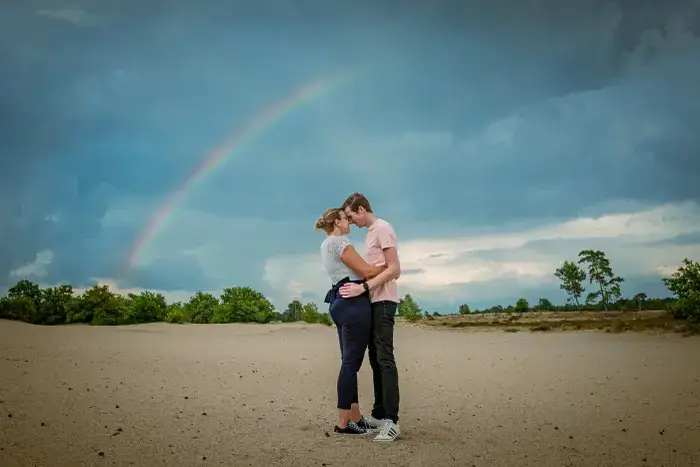 Tijdens een loveshoot verscheen er een regenboog in de duinen.