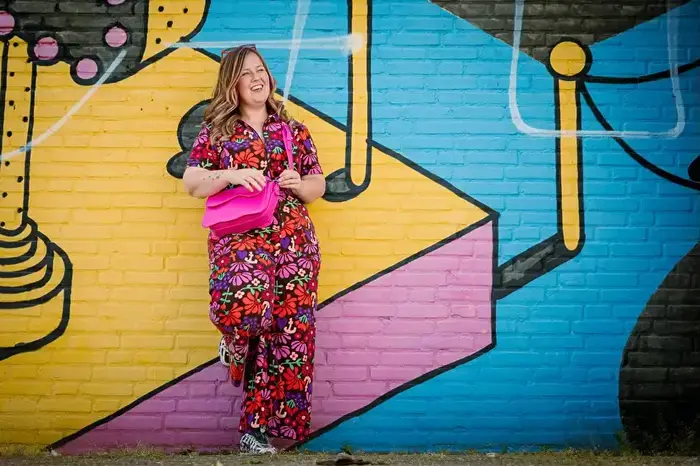 Kleurrijke vrouw poseert bij muurschildering op de Beyerd-Vlaszak parkeerplaats in Breda.