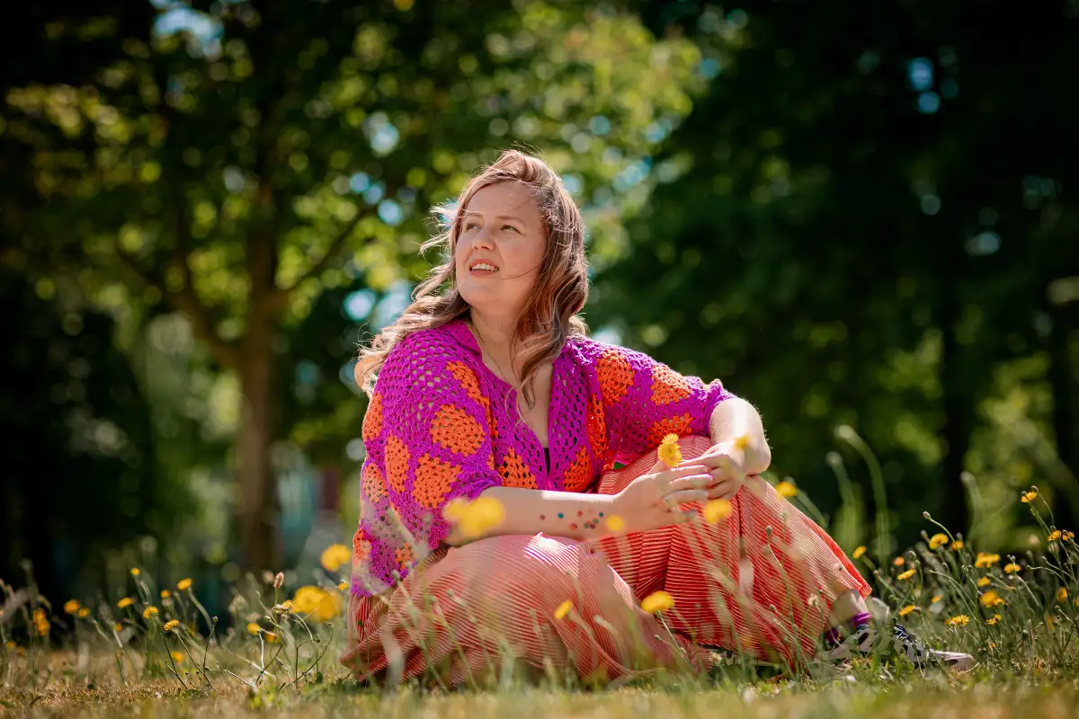 Collega fotograaf in het gras met gele bloemetjes.