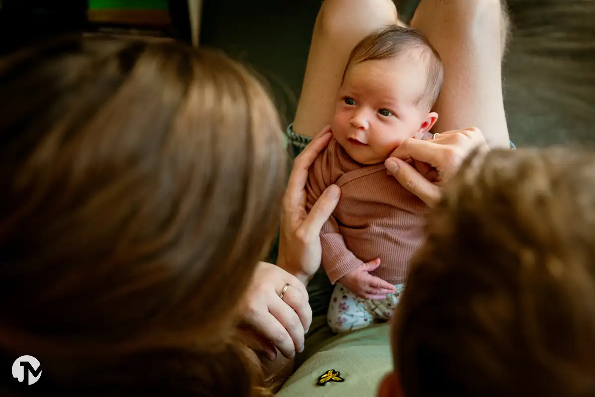 Pasgeboren meisje ligt tussen haar ouders tijdens lifestyle babyshoot