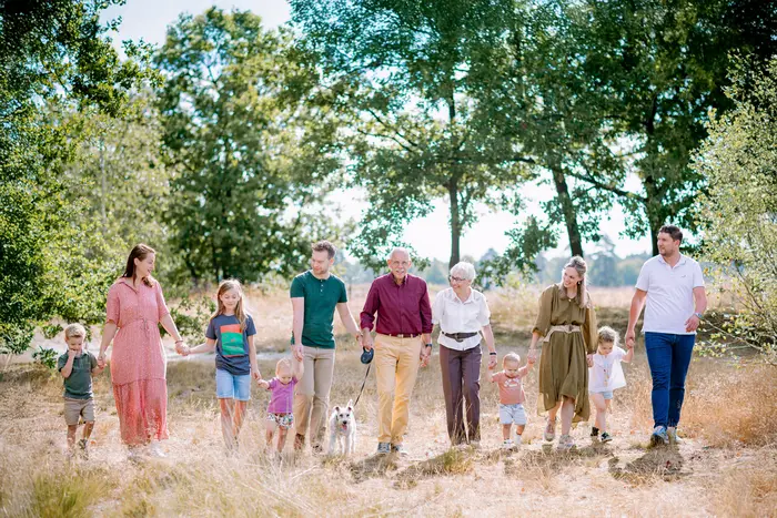 Grote familie loopt naast elkaar in de natuur in Den Bosch.