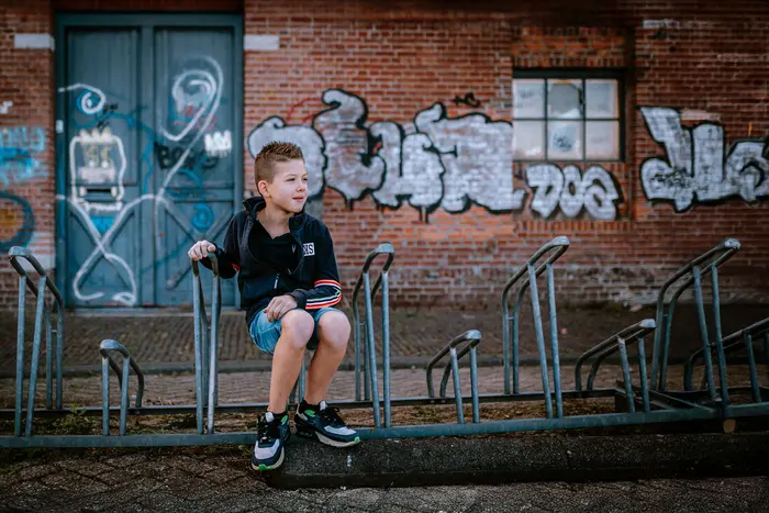 Jongen op fietsenrek op industriële locatie door fotograaf uit Den Bosch