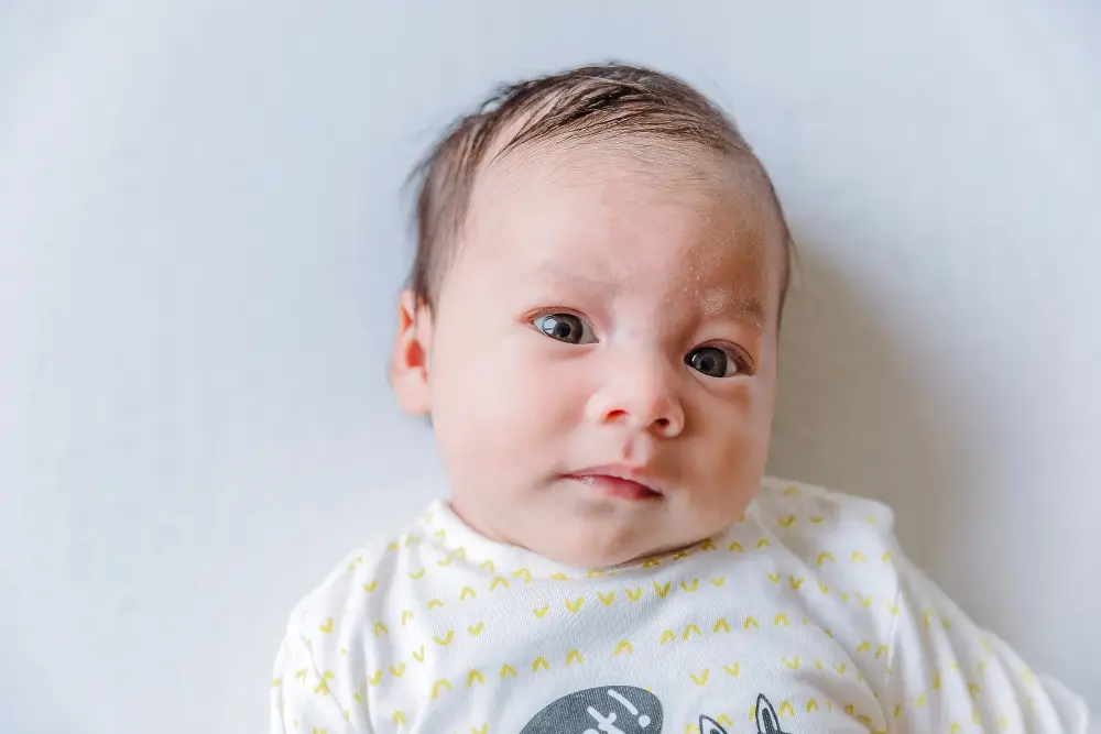 Hoofdje van wakkere baby op een witte ondergrond.