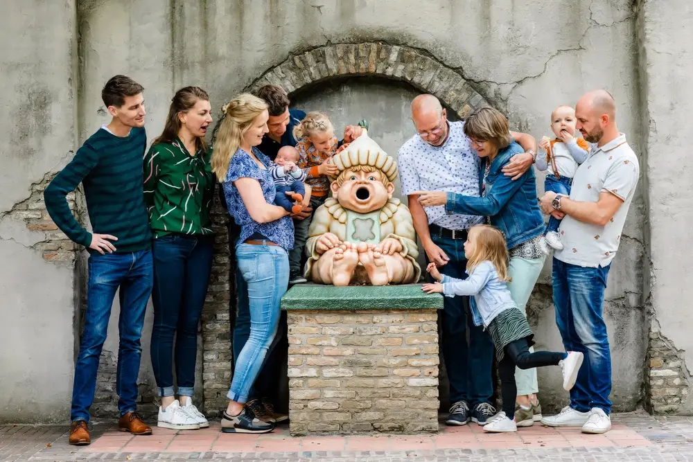 Familie poseert uit elkaar voor een huisje op het Anton Pieckplein in de Efteling.