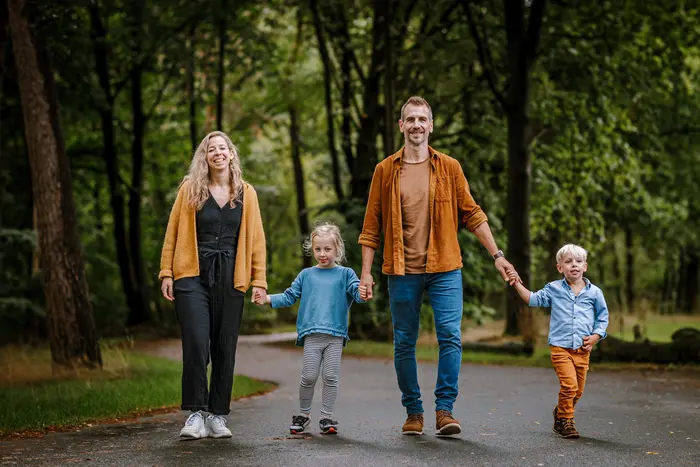 Gezin loopt tijdens een fotoshoot door het groen van het Safari Resort.