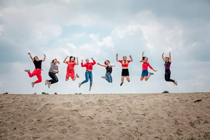 Tijdens een fotoshoot springen 8 vriendinnen in een lijn in de lucht.